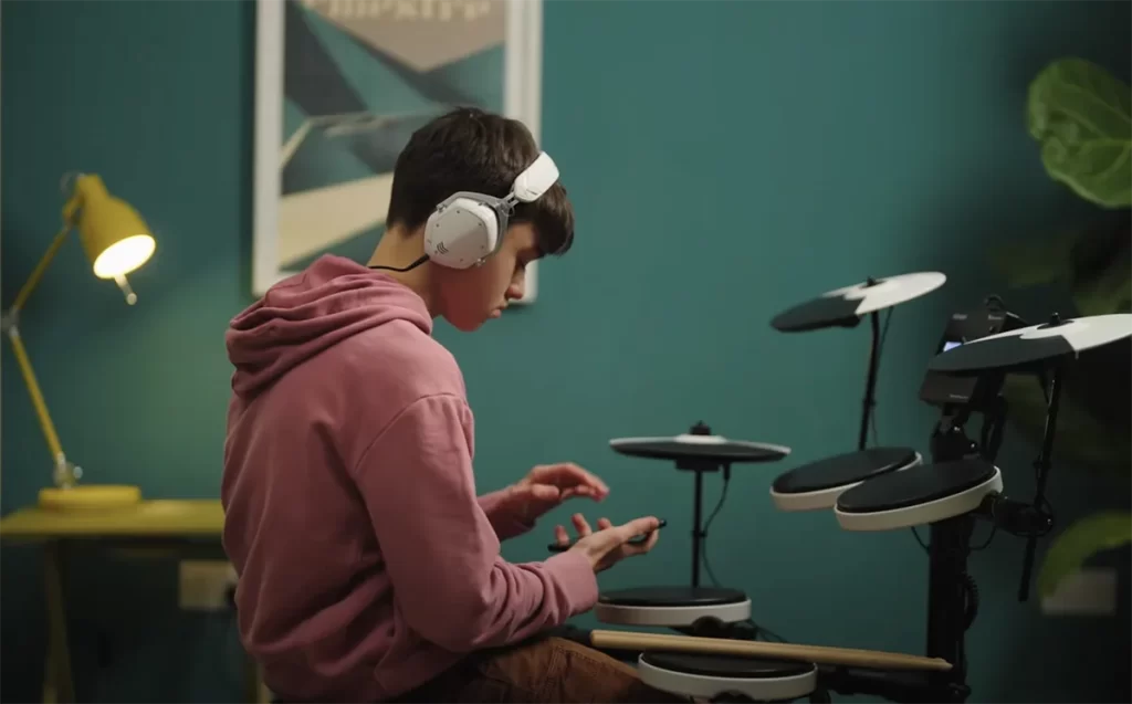 Boy drumming with phone